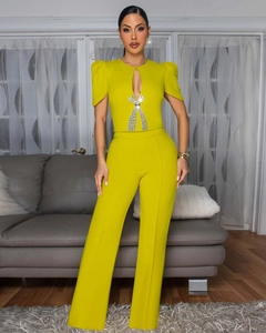 Detail view of lime yellow jumpsuit featuring rhinestone bow and teardrop cutout design