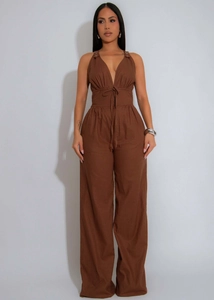 Detail of deep brown sleeveless jumpsuit featuring a halter neck and adjustable drawstring