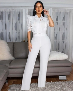 Detail von Spitzenbesatz, Puffärmeln und Schleife an diesem eleganten weißen Jumpsuit