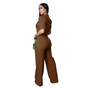 Detail of brown short sleeve jumpsuit featuring a high waist and wide leg cut in a workwear style