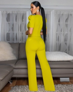 Detail view of the lime green puff sleeve jumpsuit featuring a hidden back zipper closure