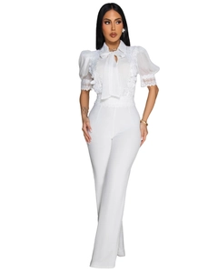 Detailansicht der eleganten Spitzenstickerei und des zarten Schleifenausschnitts am Jumpsuit