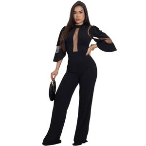 Détails d'une élégante combinaison noire avec empiècements en tulle et jambes larges