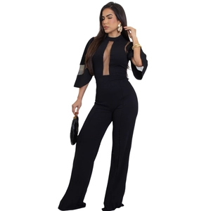 Détail de patchwork en maille et taille nouée sur une élégante combinaison noire pour femme