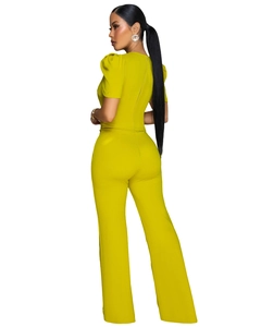 Detailed back view of lime green jumpsuit featuring puff sleeves and a metal zipper closure
