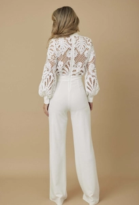 Back view of white lace long sleeve jumpsuit featuring elegant wide leg pants