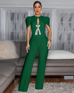 Detail of green jumpsuit featuring puff sleeves and a sparkling rhinestone bow buckle