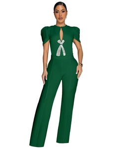Detail of dark green jumpsuit showing cutout neckline and sparkling silver bow decoration