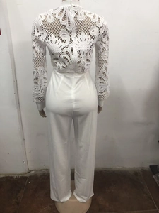 Rear view of white long sleeve jumpsuit with intricate lace crochet and high neck details