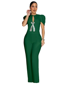 Detail of dark green jumpsuit showing puff sleeves and silver sequin bow on the chest