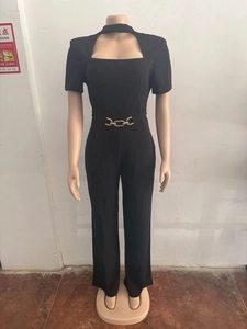 Détail de la combinaison noire élégante avec col licou et boucle de ceinture dorée