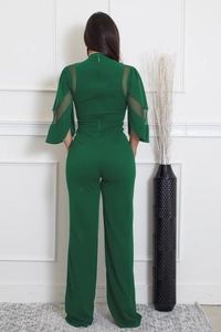 Vue détaillée du dos d'une combinaison verte avec manches en tulle et zip au dos