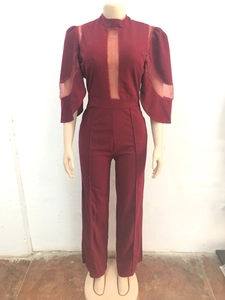 Détails du col montant en tulle et coupe large de la combinaison rouge foncé