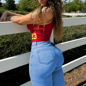 Détail d'un jean taille haute bleu clair avec design push-up et coupe ajustée