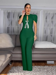 Dark green wide-leg jumpsuit with short puff sleeves and a silver sequin bow decoration
