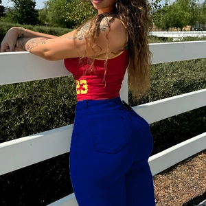 Détail du débardeur rouge avec numéro 23 et pantalon bleu ajusté pour un look décontracté