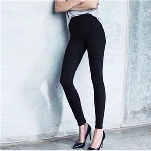 Detail of high waist black pencil pants showing slim fit silhouette and elastic fabric