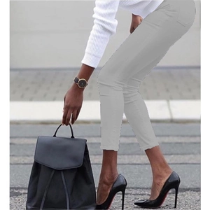 Street view of gray skinny pencil pants paired with high heels and a black backpack