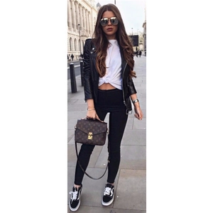 Outdoor street view of a woman in black biker leather jacket and high waist pencil pants