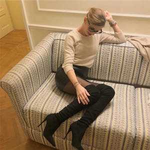 Detail view of stylish black pointed-toe stiletto over-the-knee boots in a soft faux suede material