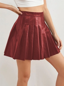Detail of burgundy pleated high-waisted faux leather skirt with elegant texture