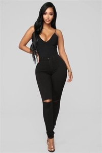 Close-up of black high waist slim jeans featuring a stylish ripped knee detail design