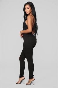 Side view of slim fit black ripped jeans with high waist design and elastic denim fabric