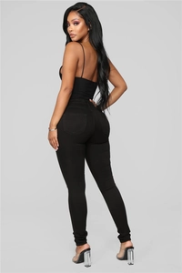 Rear view of high-waisted black skinny jeans with elastic fabric showing a slim fit