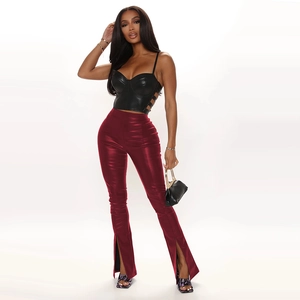 Détail du pantalon évasé en similicuir bordeaux à taille haute et fente frontale