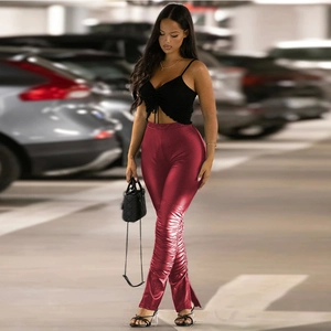 Detail view of red faux leather stacked trousers featuring side slits and ruched hem design