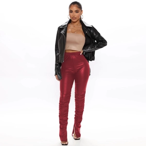 Detail of red PU leather stacked trousers with ruched design and inner ankle slits