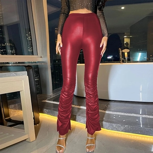 Detail of burgundy high-waisted stacked PU leather pants with ankle slits and glossy finish