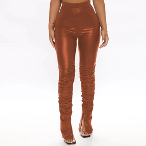 Detailed view of high-waist copper faux leather leggings with side ruching and front hem slits