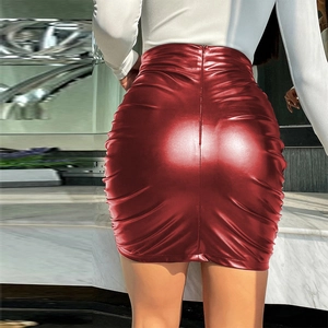 Détail de la jupe en similicuir rouge à taille haute avec fronces et fermeture éclair cachée