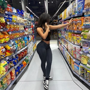 Detail of high waisted skinny jeans in dark grey and black crop top in a grocery store