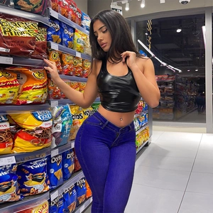 Detail view of high-waist stretchy skinny jeans paired with a cropped black halter top