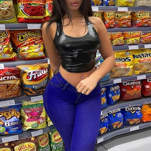 Detail of high waisted skinny jeans paired with a glossy black PU leather crop top