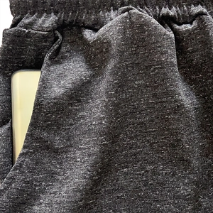 Detail view of heather grey yoga pants showing elastic waistband and deep functional side pockets