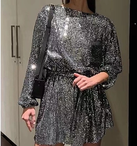 Detail of silver sequined mini dress featuring long sleeves and a slim waistline cut