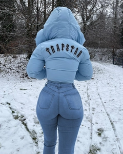Rear view of light blue quilted puffer jacket with Trapstar logo and skinny jeans