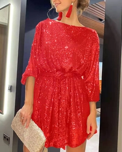 Detailed view of red sequin party dress featuring a cinched waist and shimmering texture