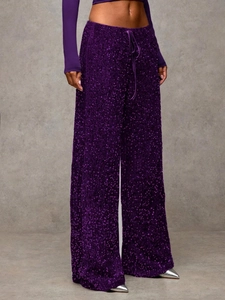 Detail of shimmering deep purple sequin wide-leg pants with velvet texture and drawstring