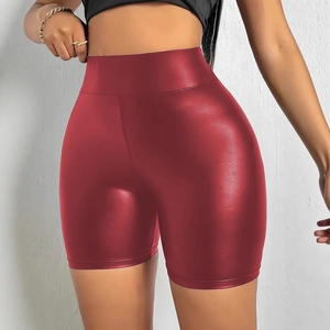 Dettaglio dei pantaloncini in ecopelle rosso scuro con finitura lucida e vita alta
