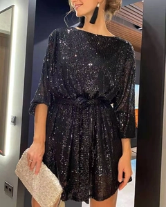 Close-up of sparkling black sequin mini dress with cinched waist and elegant crew neck