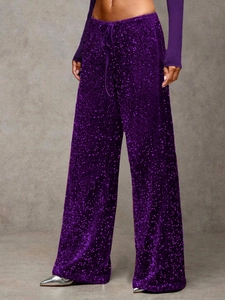 Detailed close-up of high-waisted purple sequined trousers with an adjustable drawstring