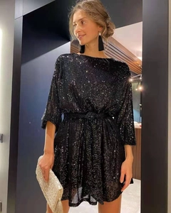 Detail of elegant black sequin dress featuring shimmering metallic textures and waist tie