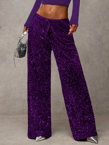 Detail of purple sequin trousers with drawstring waist and shimmering fabric texture