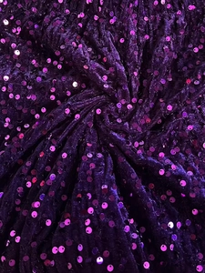 Close-up of luxury purple velvet fabric with shimmering sequins and soft draped texture
