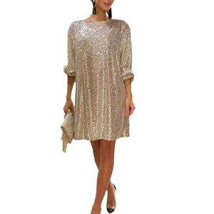 Close-up of sparkling gold sequins and long sleeves on a stylish party cocktail dress