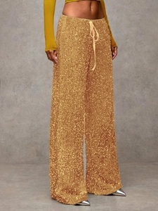 Detail of sparkling gold sequin wide-leg pants with adjustable drawstring waist and shiny finish